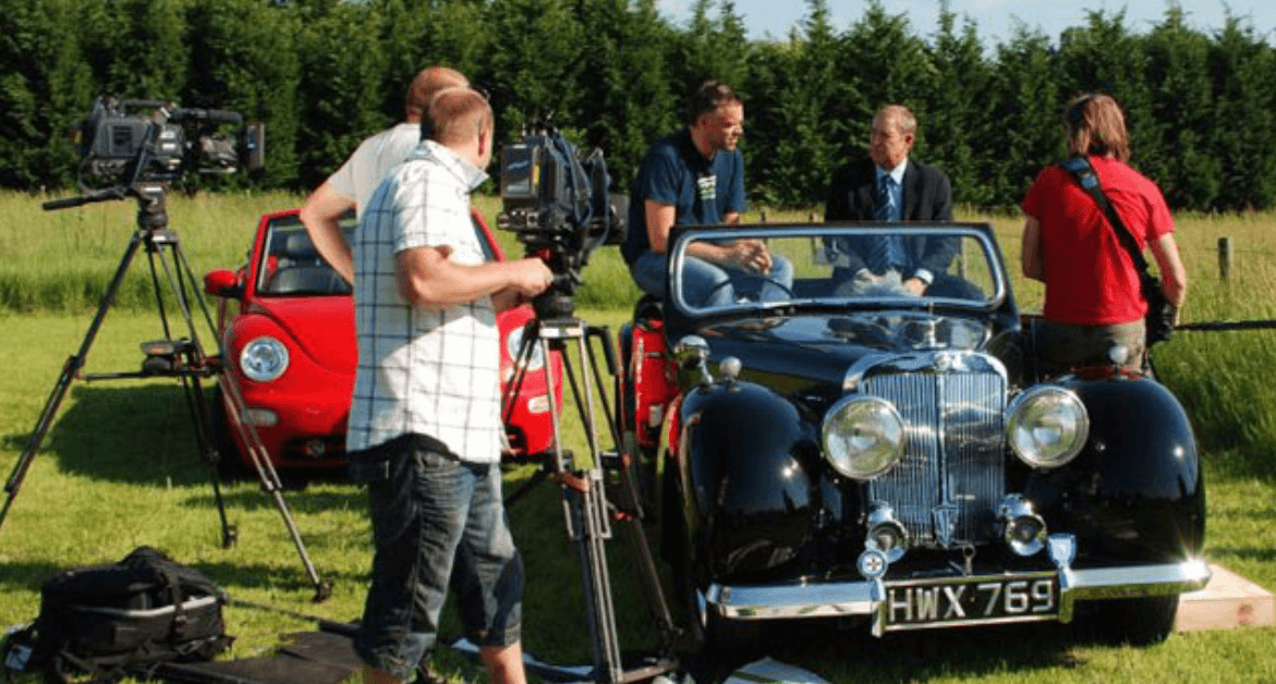 John Nettles being interviewed in a Triumph Roadster on the set of Bergerac