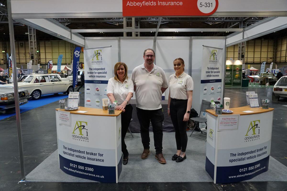 Abbeyfields Insurance staff team photo on the stand at NEC, Jayne, Stuart and Lucy